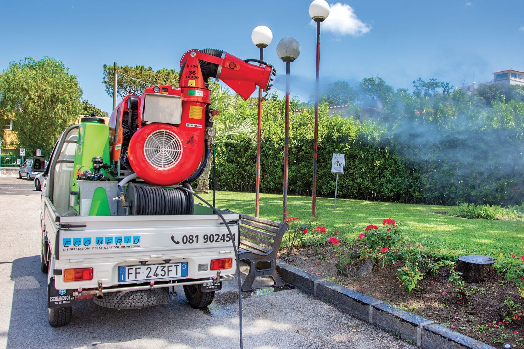 Il mezzo di Eco Merid con il nebulizzatore in funzione in un giardino pubblico